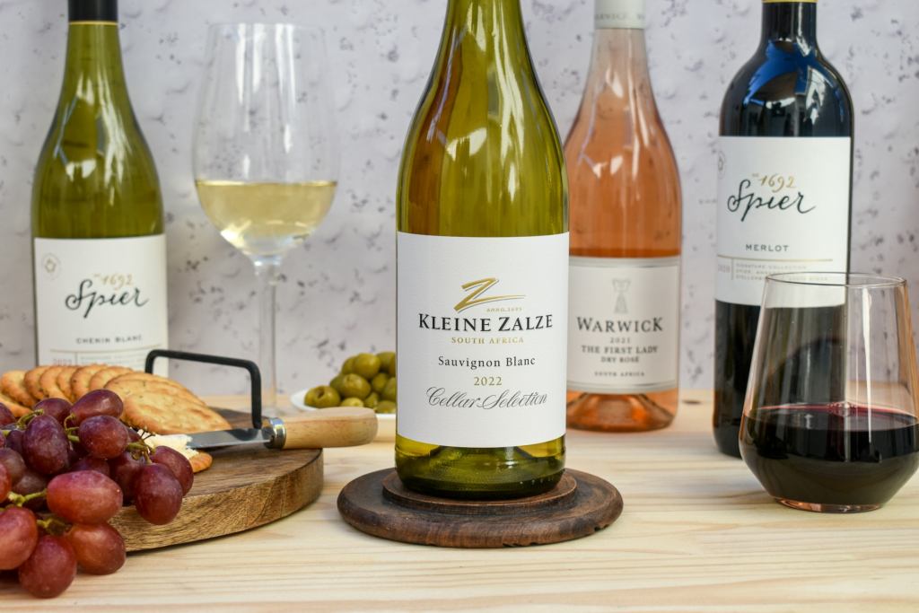 Bottles of Kleine Zalze, Spier, and Warwick wines from Stellenbosch in the Cape Town wine region, shown with glasses and snacks